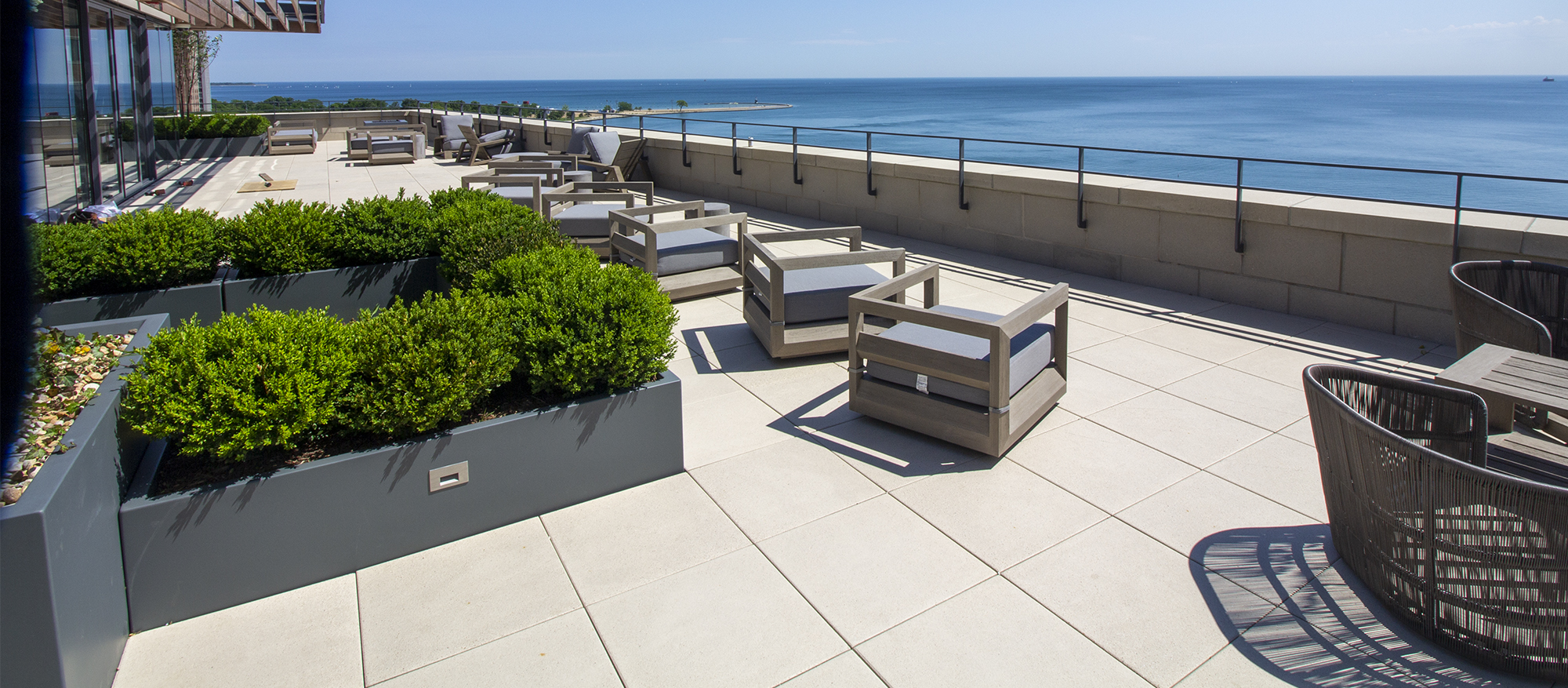 seating areas and raised gardens on a roof deck made of unilock arcana slabs offer a view of the chicago river.